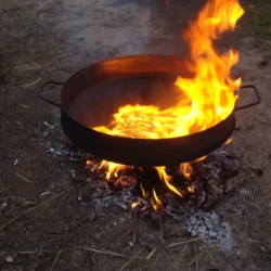 Discos de arado reales, curados con vino y listos para cocinar al fuego. Con tapa bifera, patas desmontables y sin necesidad de esmaltado.